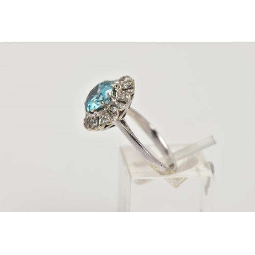 58 - A WHITE METAL GEM SET CLUSTER RING, of a flower shape, centring on a circular cut blue zircon within... 