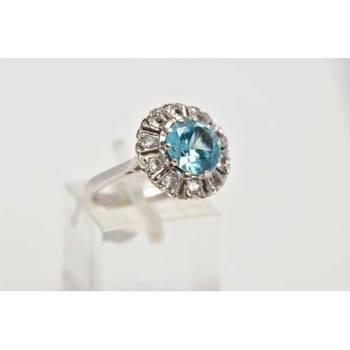 58 - A WHITE METAL GEM SET CLUSTER RING, of a flower shape, centring on a circular cut blue zircon within... 