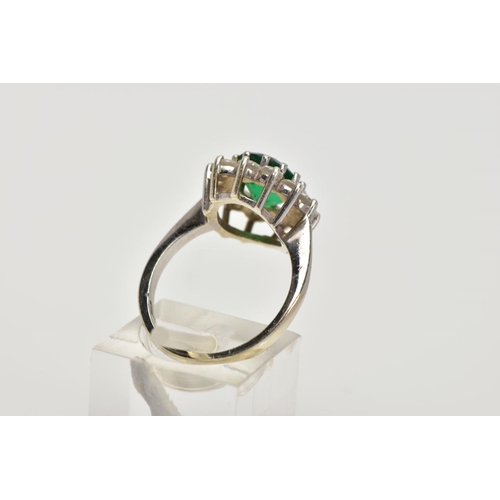 59 - A 9CT WHITE GOLD CLUSTER RING, centring on an oval cut green stone assessed as paste, within a surro... 