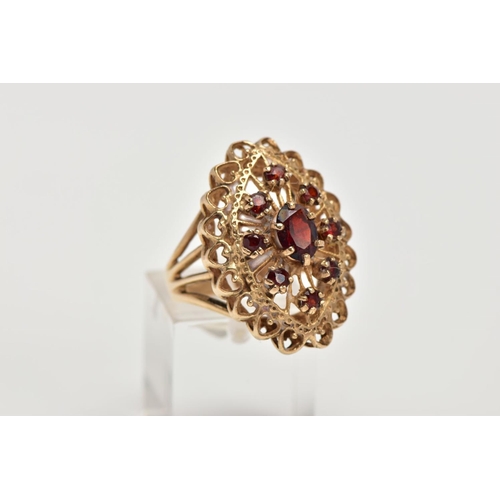 60 - A 9CT GOLD GARNET DRESS RING, of a large openwork marquise shape, set with circular cut garnets, ope... 