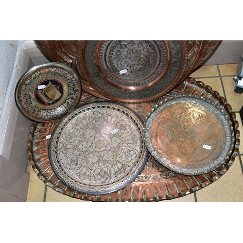 637 - A COLLECTION OF SEVEN INDIAN/MIDDLE EASTERN METAL PLATTERS, CHARGERS AND TRAYS, all either embossed ... 