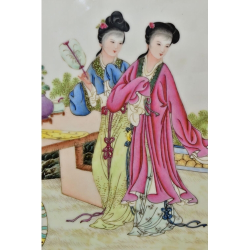 663 - A PAIR OF 20TH CENTURY FAMILE ROSE PORCELAIN PLAQUES, each depicting two female figures wearing trad... 