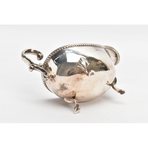 81 - AN EARLY 20TH CENTURY SILVER GRAVY BOAT, with gadrooned top edge, scrolling handle and three feet, s... 