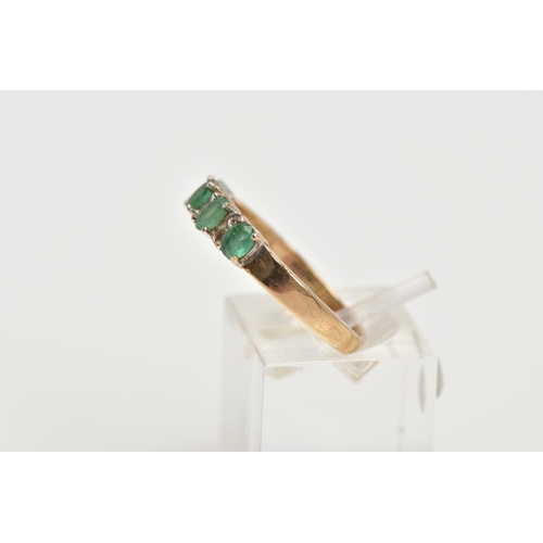 94 - A 9CT GOLD EMERALD AND DIAMOND HALF ETERNITY RING, designed with a row of four claw set oval cut eme... 