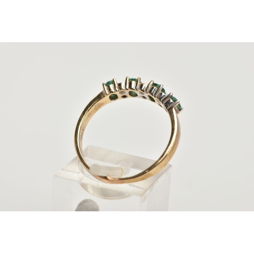 94 - A 9CT GOLD EMERALD AND DIAMOND HALF ETERNITY RING, designed with a row of four claw set oval cut eme... 