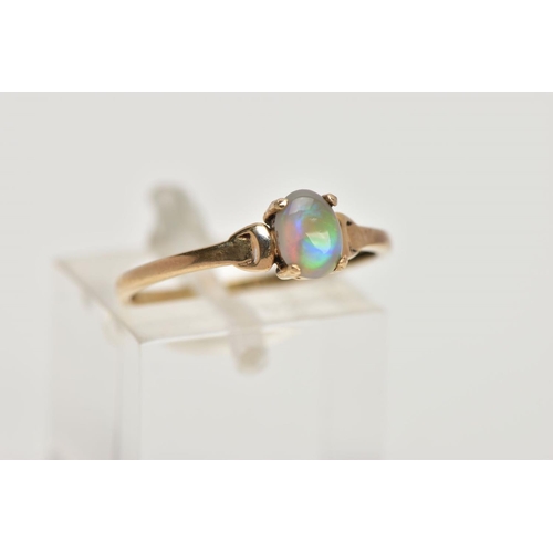 95 - A YELLOW METAL OPAL RING, designed with a claw set, oval opal cabochon, plain polished band stamped ... 