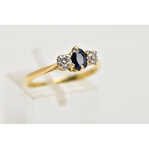 99 - AN 18CT GOLD SAPPHIRE AND DIAMOND THREE STONE RING, centring on a claw set, oval cut blue sapphire, ... 