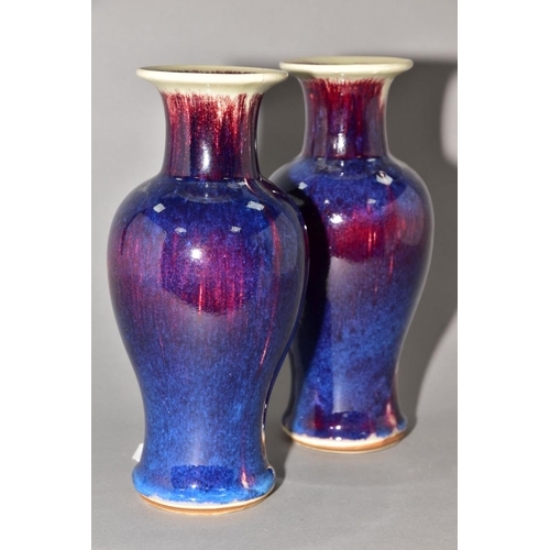 142 - A PAIR OF BALUSTER VASES covered in high fired Ruskin style glazes, unmarked, approximate height 24c... 