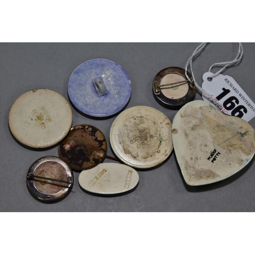 166 - A BOX OF RUSKIN ENAMELS, comprising two silver mounted brooches, a lavender glaze button, two round ... 