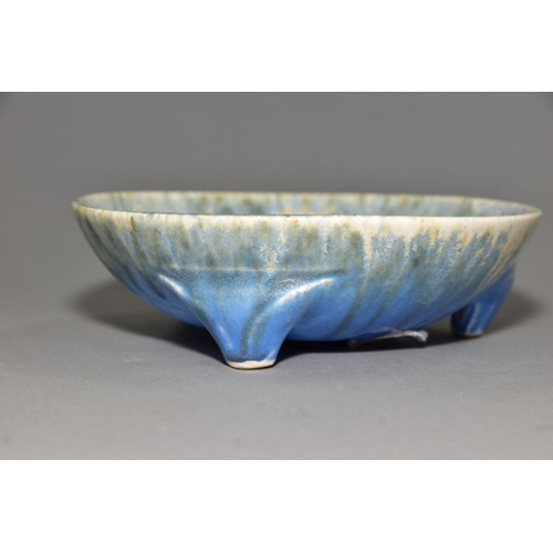 197 - RUSKIN POTTERY, a shallow bowl raised on three feet, blue and orange crystalline glaze over white gl... 