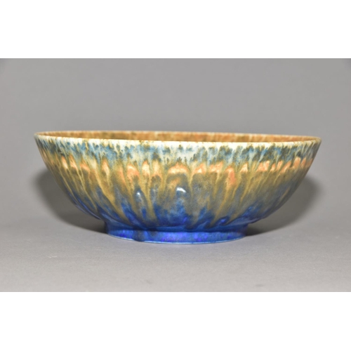 199 - RUSKIN POTTERY, a footed bowl covered in orange, green and blue glazes, impressed Ruskin England 193... 