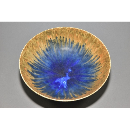 199 - RUSKIN POTTERY, a footed bowl covered in orange, green and blue glazes, impressed Ruskin England 193... 