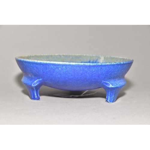 220 - RUSKIN POTTERY a bowl raised on three feet, blue crystalline glaze to the inside surface, impressed ... 