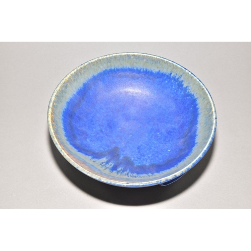 220 - RUSKIN POTTERY a bowl raised on three feet, blue crystalline glaze to the inside surface, impressed ... 