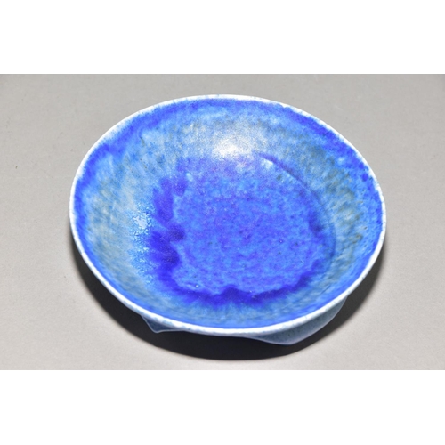 222 - RUSKIN POTTERY, a shallow bowl raised on three feet, blue crystalline glaze, impressed Ruskin Englan... 