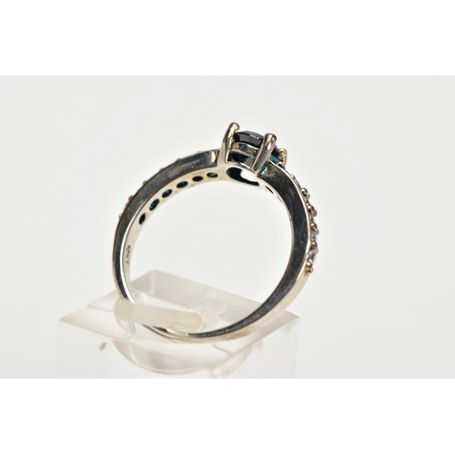 10 - A WHITE METAL CUBIC ZIRCONIA SET DRESS RING, designed with a central, circular cut black stone, flan... 