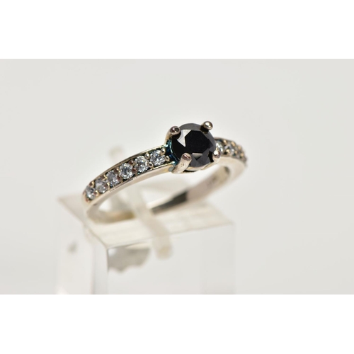 10 - A WHITE METAL CUBIC ZIRCONIA SET DRESS RING, designed with a central, circular cut black stone, flan... 