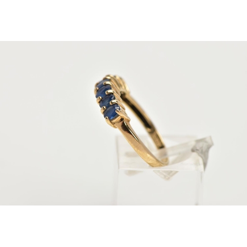 12 - A 9CT GOLD SAPPHIRE DRESS RING, of a half hoop design, set with a row seven claw set, oval cut, blue... 