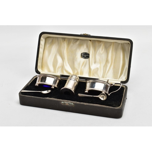 163 - A THREE-PIECE SILVER CONDIMENT SET, comprising of a salt and mustard each with a blue glass lining, ... 