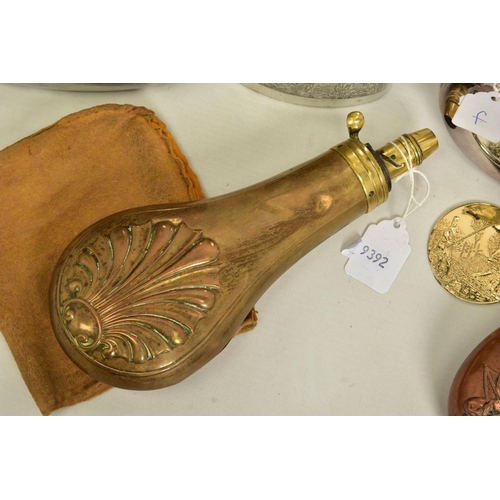 135 - A BOX CONTAINING TWO BLACK POWDER FLASKS, decorated and three drinking hip flasks, two are boxed