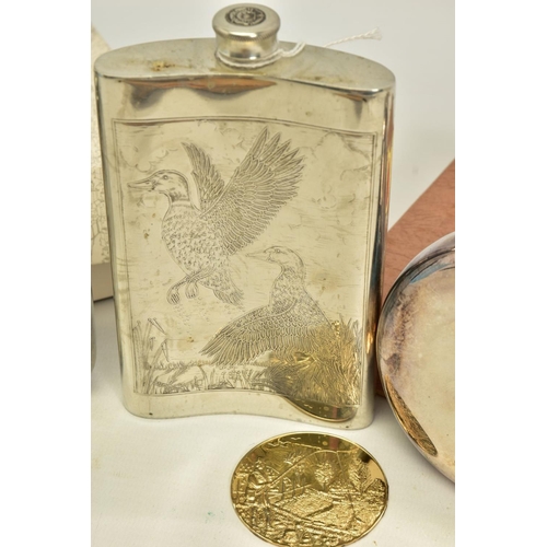 135 - A BOX CONTAINING TWO BLACK POWDER FLASKS, decorated and three drinking hip flasks, two are boxed