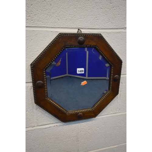 1409 - A MID 20TH CENTURY OAK BEVELLED EDGE OCTAGONAL WALL MIRROR, diameter 42cm