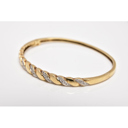 165 - A 9CT GOLD DIAMOND SET HINGED BANGLE, of twist design, set with diagonal sections of single cut diam... 