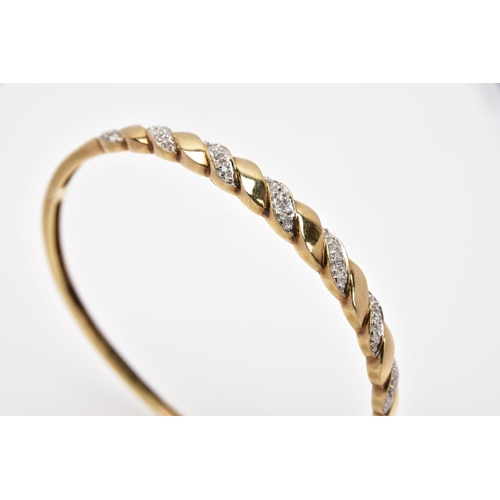 165 - A 9CT GOLD DIAMOND SET HINGED BANGLE, of twist design, set with diagonal sections of single cut diam... 