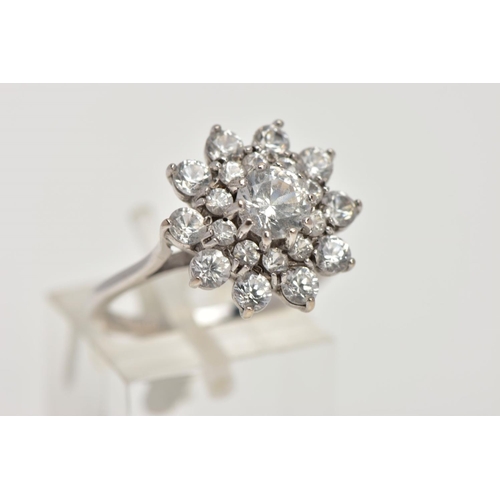 186 - A WHITE METAL SPINEL CLUSTER RING, slightly raised, large flower shape cluster, set with circular cu... 