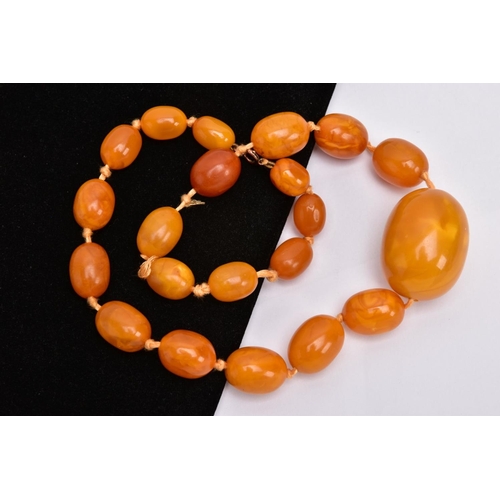 191 - A GRADUATED NATURAL AMBER BEAD NECKLACE, comprising twenty-one barrel shape beads measuring approxim... 