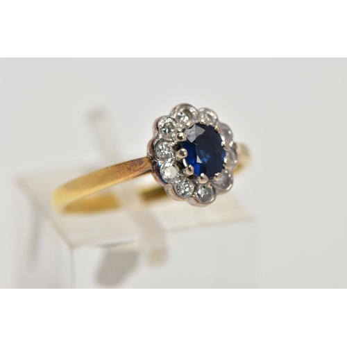 199 - AN 18CT GOLD SAPPHIRE AND DIAMOND CLUSTER RING, the central oval sapphire in a ten claw setting with... 