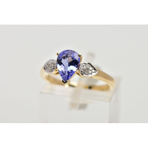 201 - A 9CT GOLD TANZANITE AND DIAMOND RING, the central pear shape tanzanite in a three claw setting, eac... 