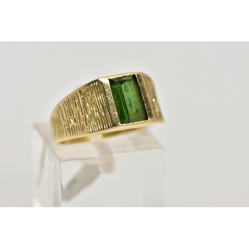 251 - A YELLOW METAL TOURMALINE RING, designed with a rectangular cut green tourmaline, textured shoulders... 