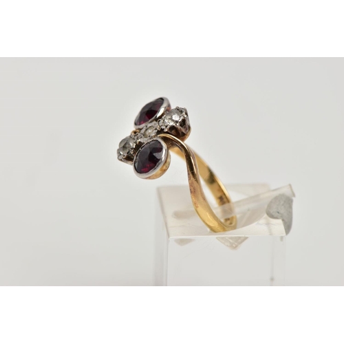 256 - AN EARLY 20TH CENTURY 18CT GOLD GARNET AND DIAMOND DRESS RING, of a cross over design, the centre pi... 