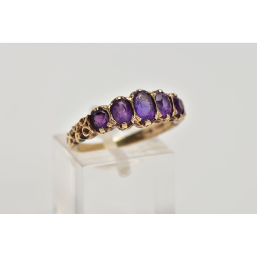 270 - A 9CT GOLD FIVE STONE AMETYHST RING, designed with a row of five graduated oval cut amethyst, scroll... 