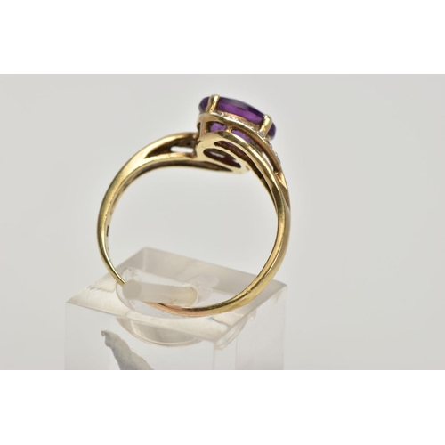 275 - A 9CT GOLD AMETHYST AND DIAMOND CROSS OVER RING, designed with a central oval cut amethyst, single c... 