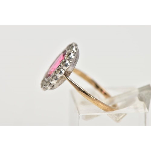 306 - A 9CT GOLD AND SILVER CLUSTER RING, centring on an oval cut pink stone assessed as paste, within a m... 