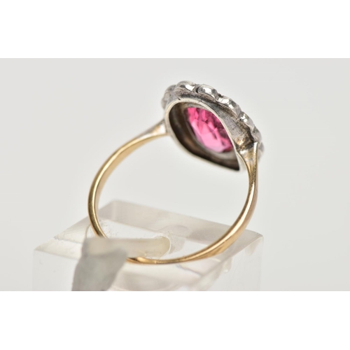 306 - A 9CT GOLD AND SILVER CLUSTER RING, centring on an oval cut pink stone assessed as paste, within a m... 