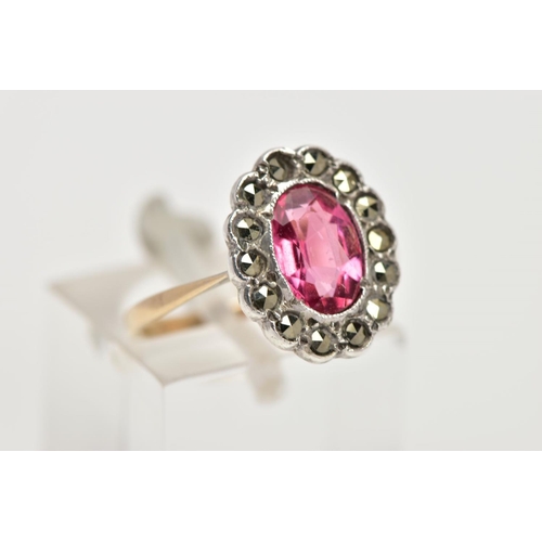 306 - A 9CT GOLD AND SILVER CLUSTER RING, centring on an oval cut pink stone assessed as paste, within a m... 