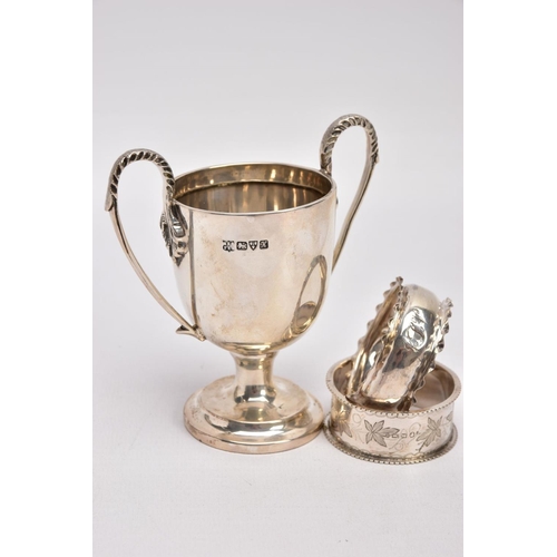 366 - A MINIATURE SILVER TROPHY CUP AND TWO SILVER NAPKIN RING, plain polished body raised on a circular s... 