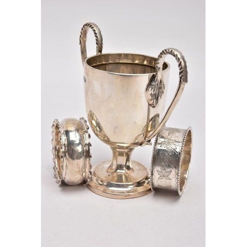 366 - A MINIATURE SILVER TROPHY CUP AND TWO SILVER NAPKIN RING, plain polished body raised on a circular s... 