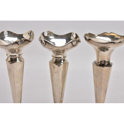 383 - THREE SILVER POSY VASES, each with a wavy rim, two with tapered square stems, one with a tapered oct... 