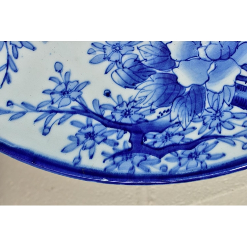 501 - A LATE 19TH CENTURY JAPANESE PORCELAIN CHARGER, blue and white decoration of an exotic bird amongst ... 