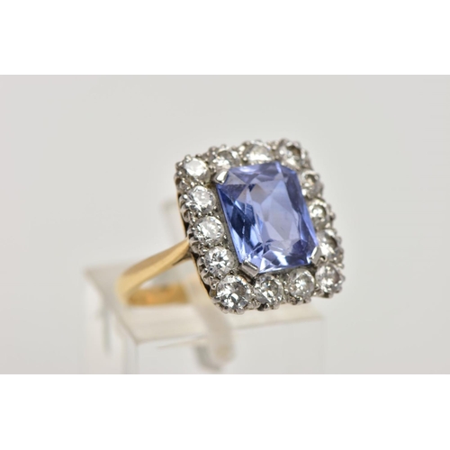 336 - A MID TO LATE 20TH CENTURY SAPPHIRE AND DIAMOND CLUSTER RING, an emerald cut purplish blue sapphire,... 