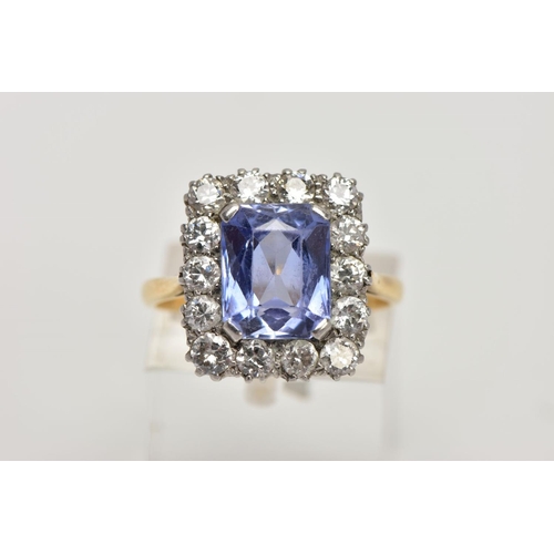 336 - A MID TO LATE 20TH CENTURY SAPPHIRE AND DIAMOND CLUSTER RING, an emerald cut purplish blue sapphire,... 