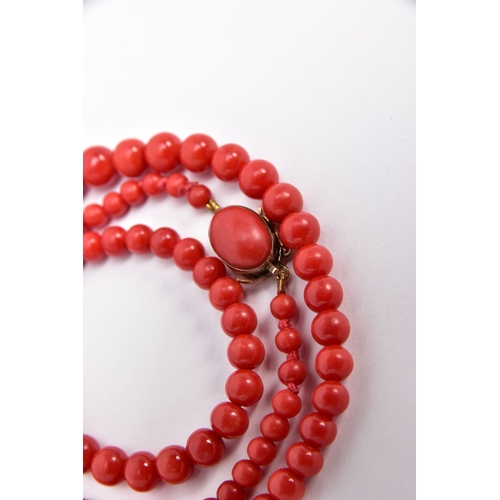 395 - A DYED CORAL BEAD NECKLACE, designed as a row of graduated dyed coral beads measuring approximately ... 