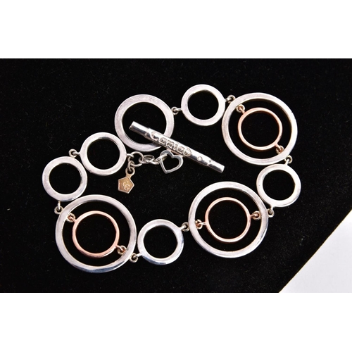 48 - A CLOGAU SILVER AND GOLD BRACELET, openwork rose gold and silver circular links, fitted with a signe... 