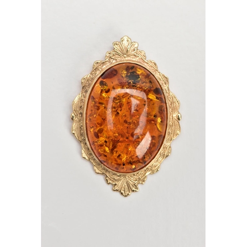 111 - A 9CT GOLD AMBER PENDANT, large oval amber cabochon, collet mounted within a decorative foliate surr... 