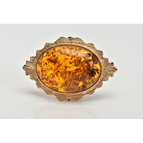 111 - A 9CT GOLD AMBER PENDANT, large oval amber cabochon, collet mounted within a decorative foliate surr... 