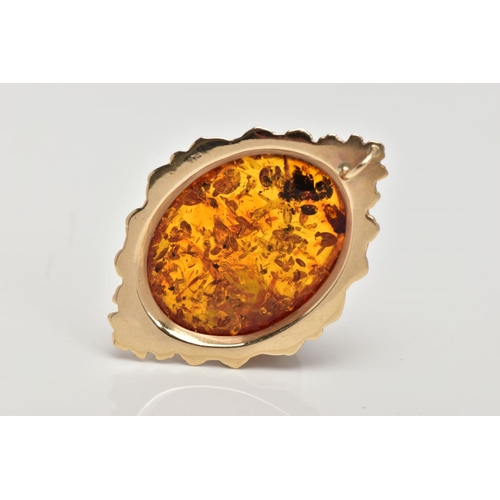 111 - A 9CT GOLD AMBER PENDANT, large oval amber cabochon, collet mounted within a decorative foliate surr... 